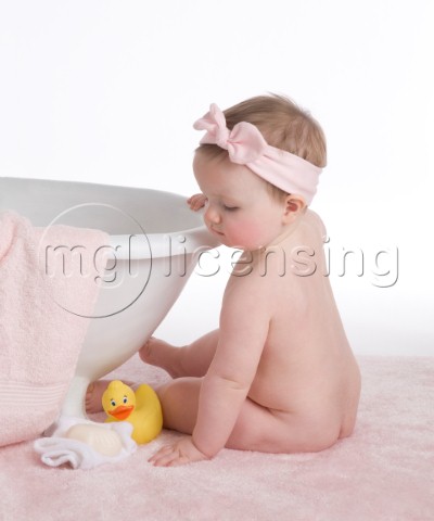 Baby with pink bow on towel
