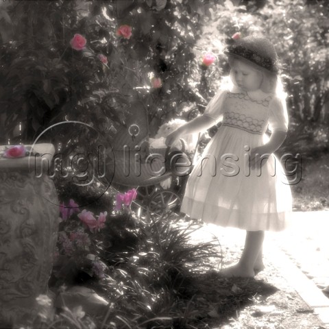 Girl with watering can watering the roses